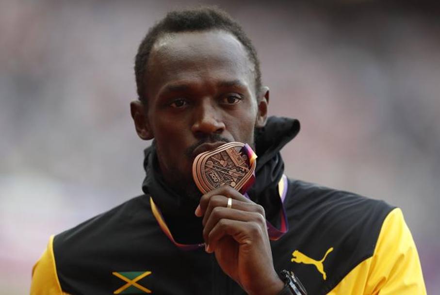 Bolt non appare molto convinto mentre bacia la medaglia di bronzo